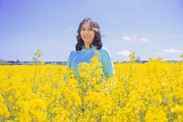 우크라이나의 국기와 같은 유채 밭 yellowblue 배경에 젊은 여자