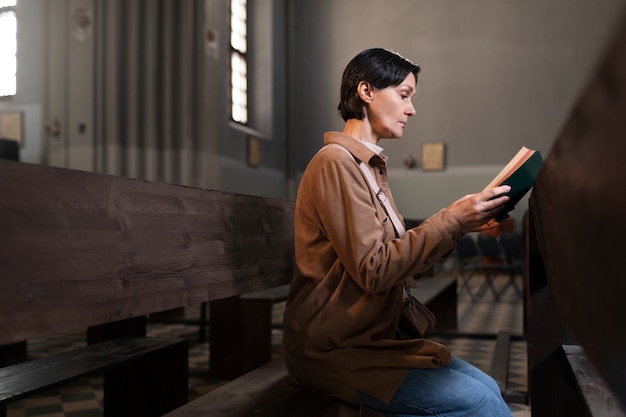 Foto giovane donna che legge la bibbia nella chiesa