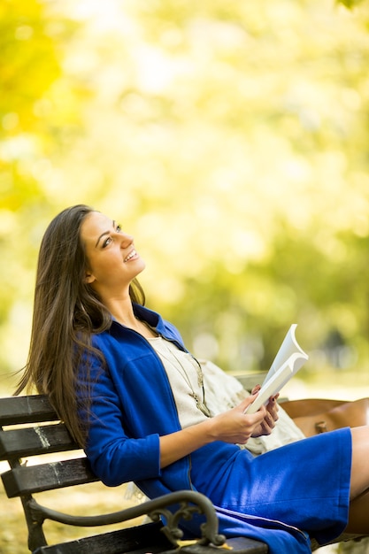 公園で本を読んでいる若い女性