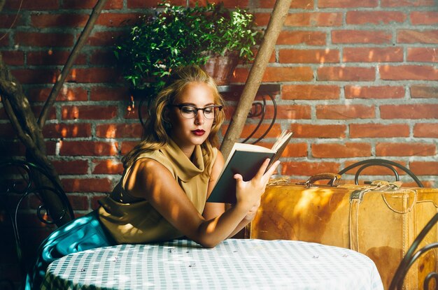 Photo young woman reading book at table