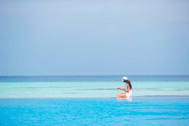 Young woman reading book during tropical white beach