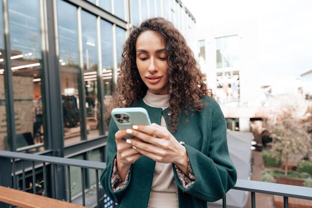 Foto giovane donna che legge un messaggio o usa il telefono in città