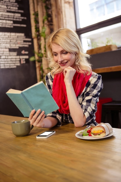 식당에서 소설을 읽는 젊은 여자