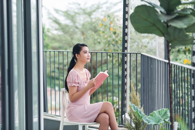 若い女性はバルコニーで本を読む