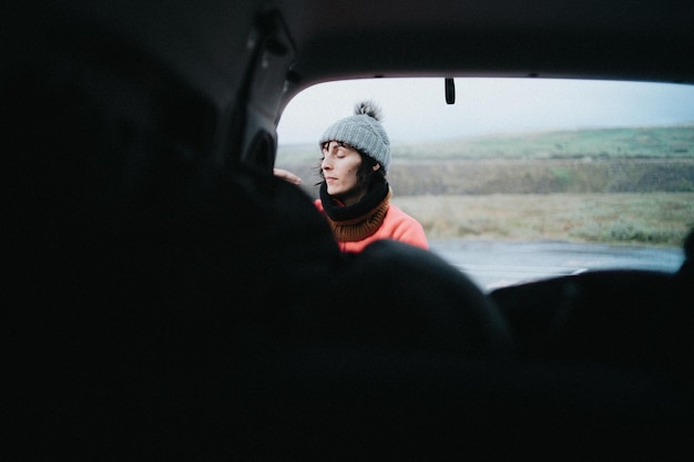 Young woman next to the rear door of a van while preparing for a travelNomadic vanlife lifestyle Life on the road