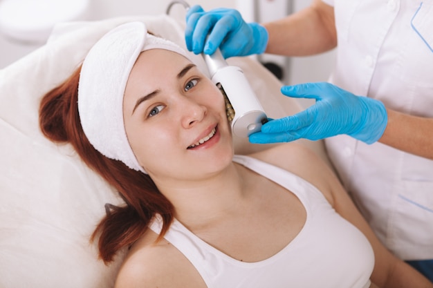 Young woman receiving endospheres facial treatment at beauty clinic