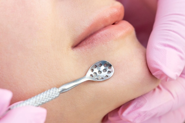 Young woman receiving facial cleansing treatment