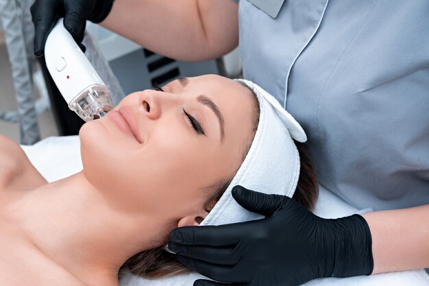 Young woman receiving laser treatment in cosmetology clinic