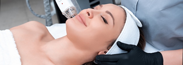 Giovane donna che riceve il trattamento laser nella clinica di cosmetologia