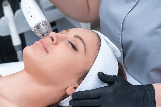 Young woman receiving laser treatment in cosmetology clinic