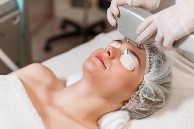 Photo young woman receiving laser treatment