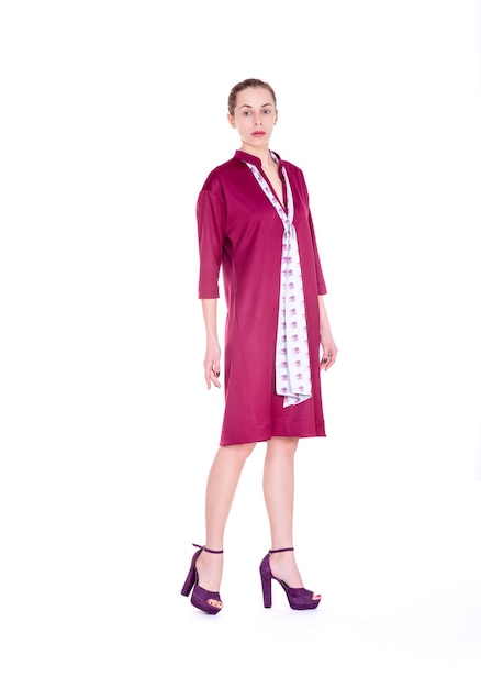 Young woman in a red dress on a neutral white background