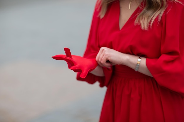 Young woman in red dress puts on medical gloves