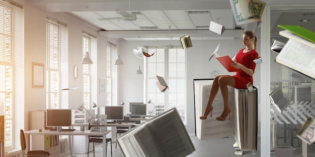 Young woman in a red dress reading a book with other books flying around. Mixed media