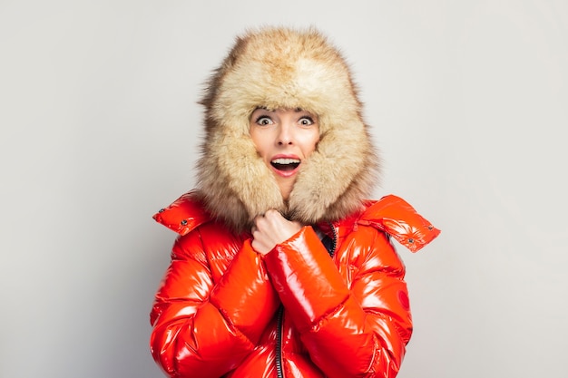 Photo young woman in a red jacket and a fur hat isolated