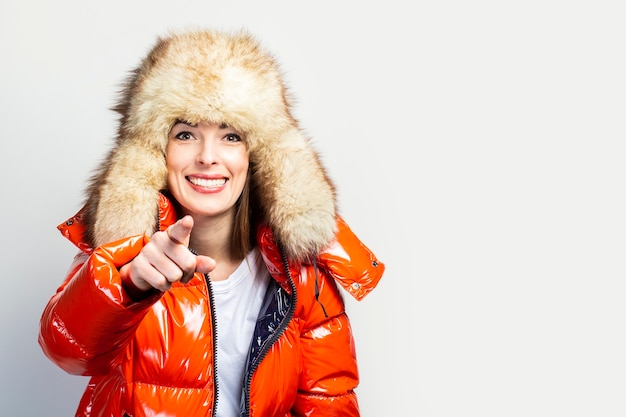 Young woman in a red jacket and a fur hat isolated