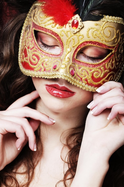 Young woman in a red mysterious mask