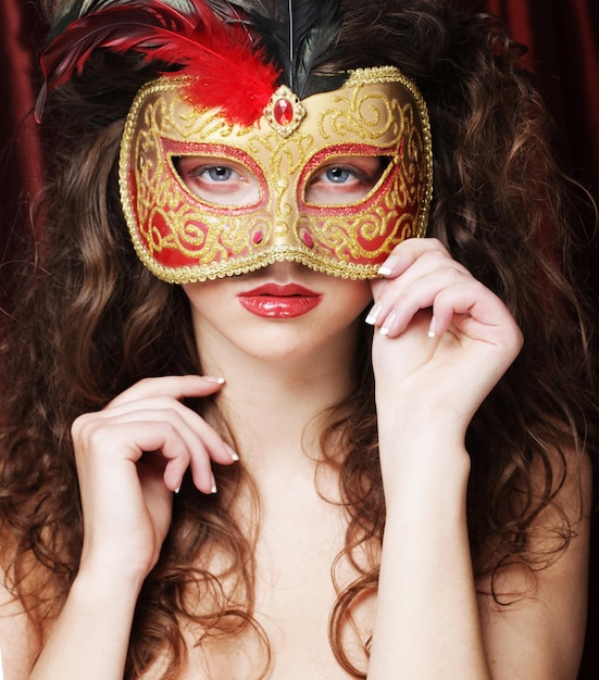 Young woman in a red mysterious mask
