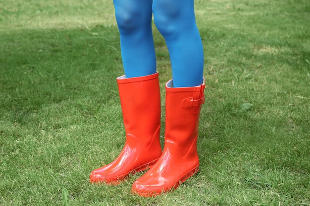 Young woman in red rubber boots outdoors