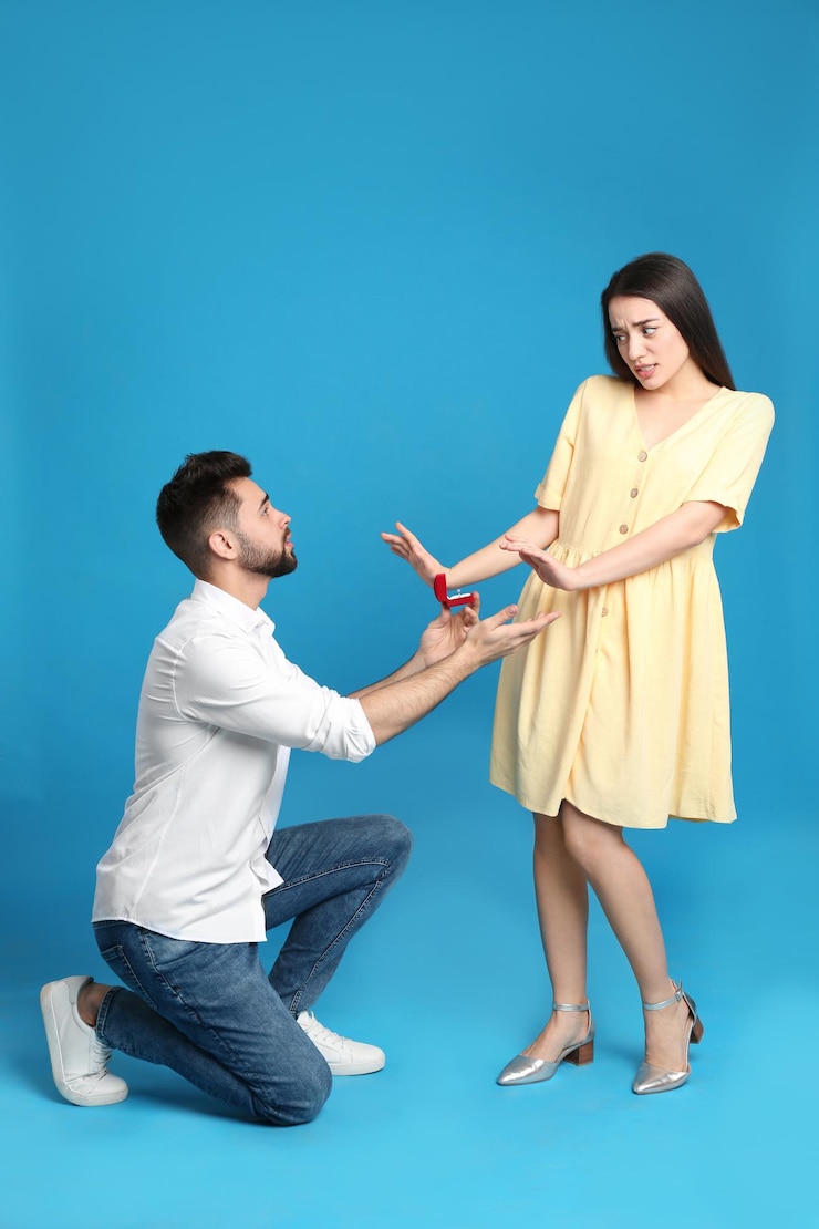 फोटो young woman rejecting engagement ring from boyfriend on blue background