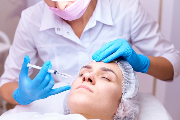 Young woman on rejuvenation procedure in a cosmetology clinic