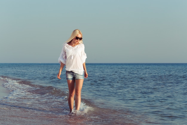 Giovane donna che si distende sulla spiaggia