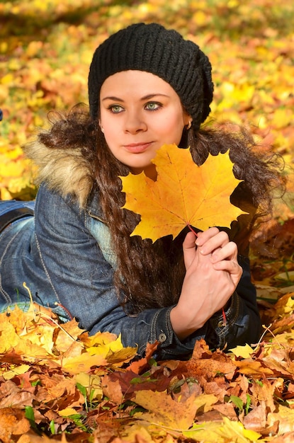 Young woman relaxing in bright autumn leaves