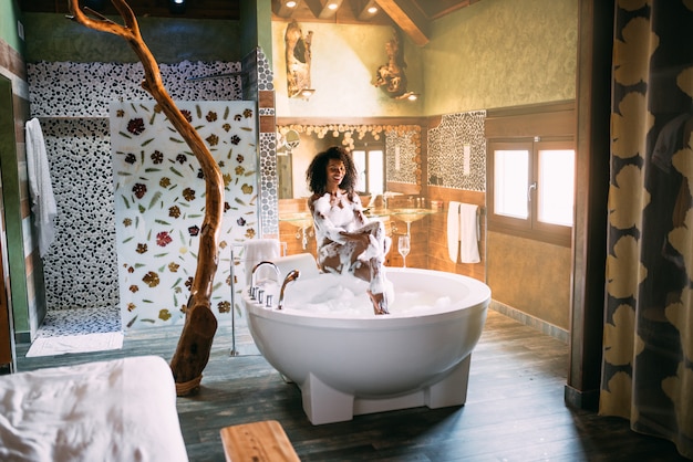 Young woman relaxing in the hydro massage bath covered in foam