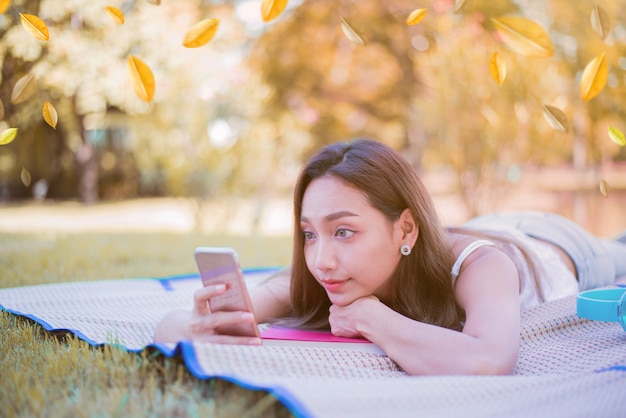 Young woman relaxing in the natural park. Vacation on Autumn season.