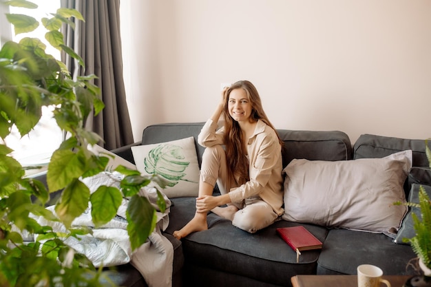 Young woman relaxing on the sofa and reading a book