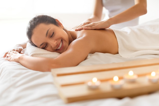 Young woman relaxing in spa salon during massage session indoor