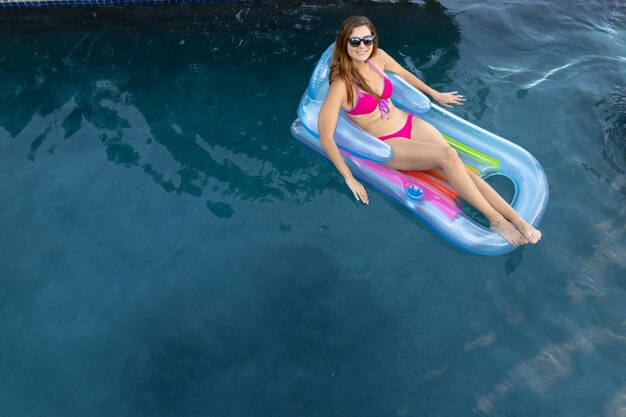 Young woman relaxing in the swimming pool