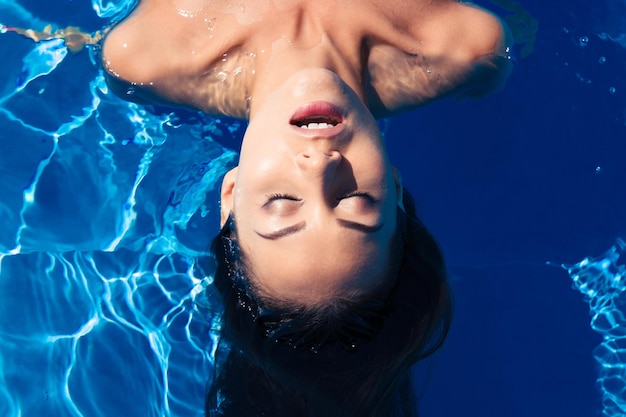 Young woman relaxing in the swimming pool