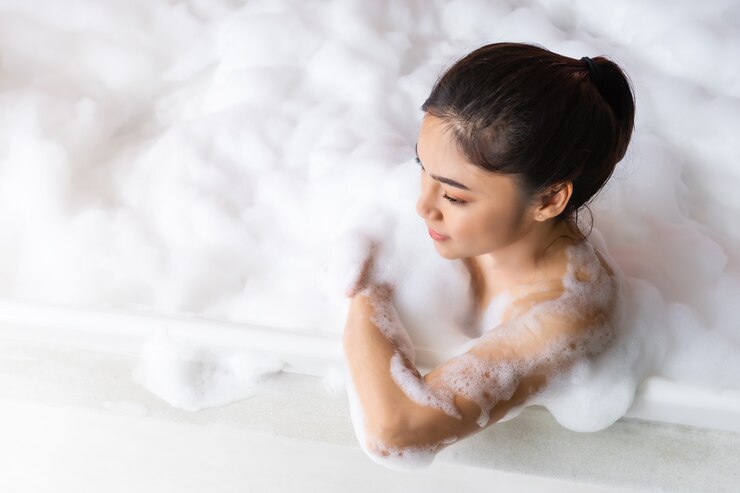 リラックスして泡風呂で泡風呂に入る若い女性