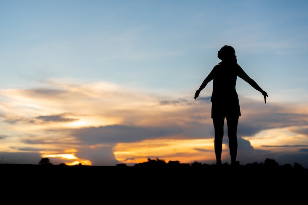 Young woman relaxing whit sunset sky outdoor.