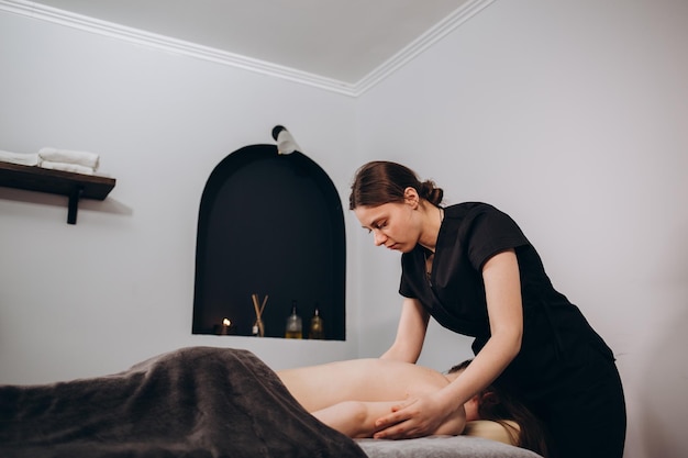 Young woman relaxing with hand massage at beauty spa