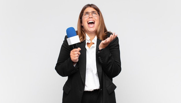 Young woman reporter looking desperate and frustrated, stressed, unhappy and annoyed, shouting and screaming