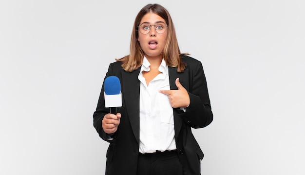 口を大きく開けてショックを受けて驚いた若い女性記者が自分を指差して