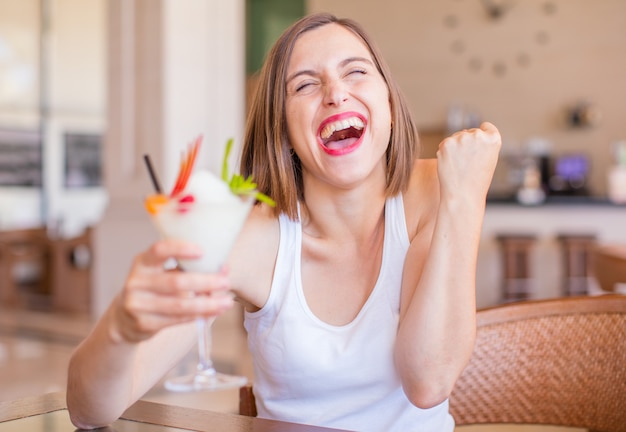 Foto giovane donna in un resort con cocktail