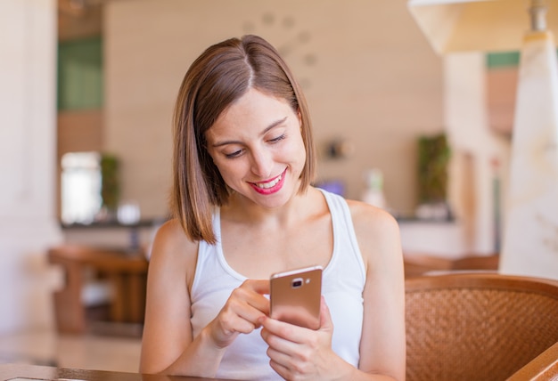 携帯電話を持つリゾートの若い女性