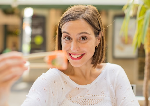 young woman in a restaurant having sushi