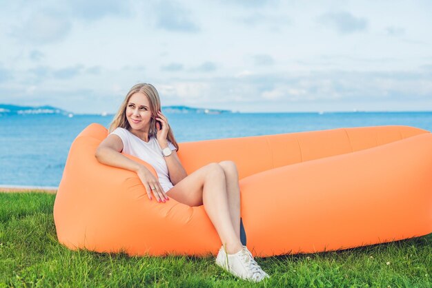 Young woman resting on an air sofa in the park