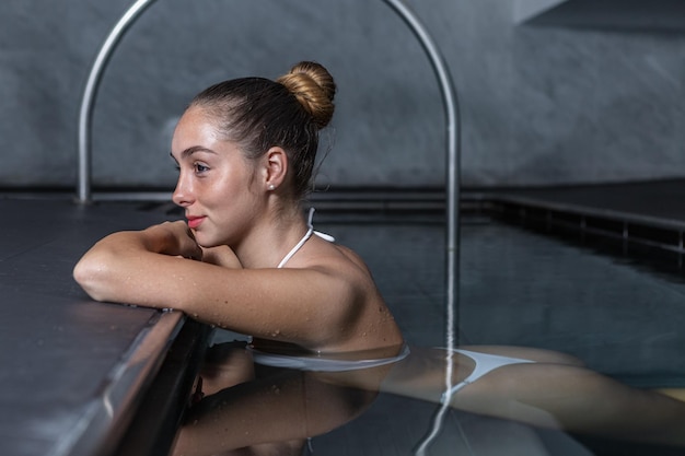 Молодая женщина отдыхает в чистом бассейне