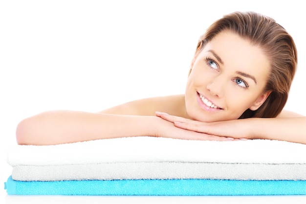 a young woman resting her head on towels over white background