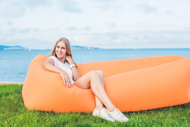 Фото Молодая женщина, отдыхая на воздушном диване в парке.
