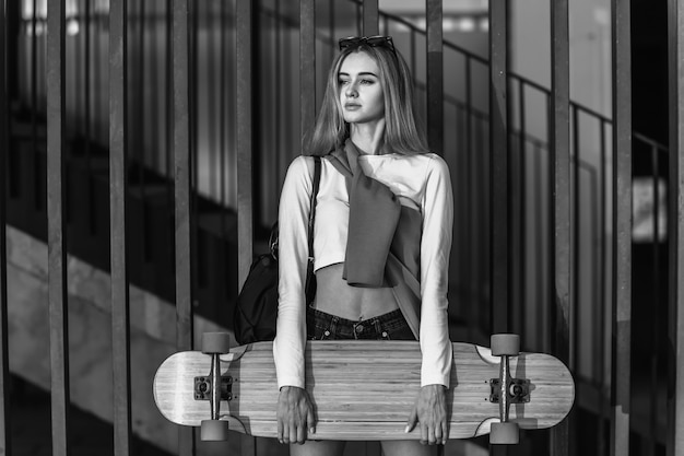 Young woman rides a longboard around the city. High quality photo