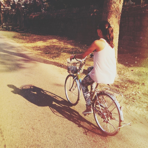 写真 道路で自転車に乗っている若い女性