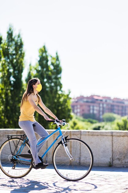 Foto giovane donna in bicicletta per strada