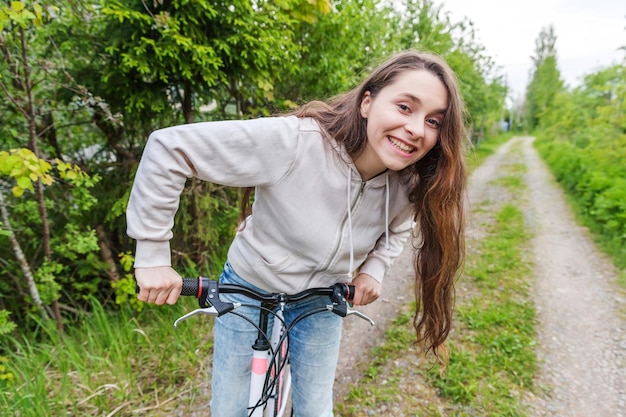 Young woman riding bicycle in summer city park outdoors Active people Hipster girl relax and rider bike