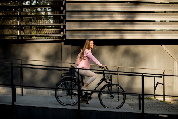 Молодая женщина, езда на велосипеде в городской среде